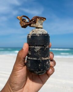 Leia mais sobre o artigo Voluntários do projeto Mar Sem Lixo encontram granada com pino durante mutirão de limpeza na praia em Arraial do Cabo 